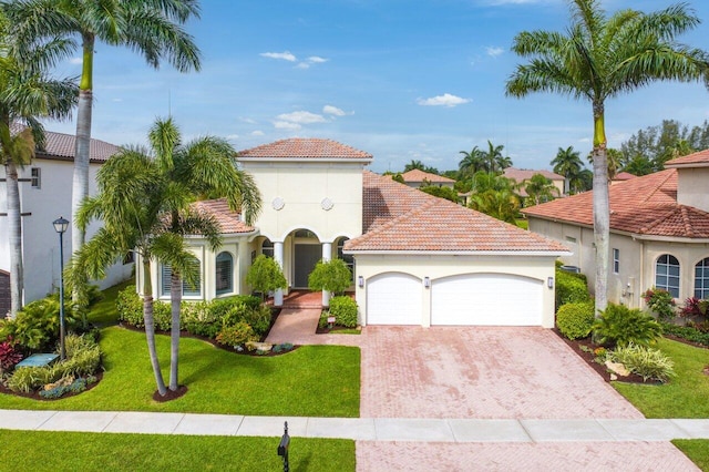 mediterranean / spanish-style home featuring a front yard and a garage