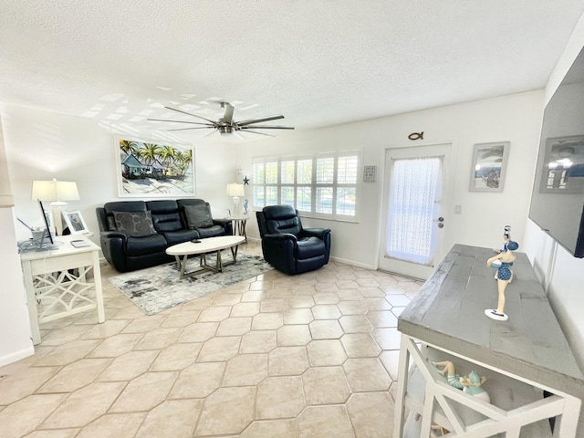 living room with ceiling fan, light tile floors, and a textured ceiling