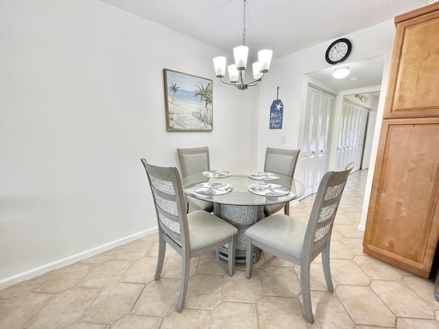 dining area featuring a textured ceiling, a notable chandelier, and light tile floors