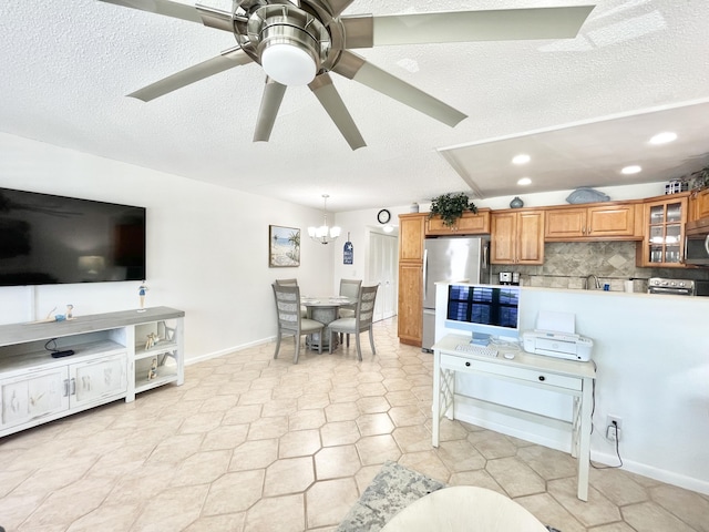 tiled living room featuring ceiling fan with notable chandelier and a textured ceiling