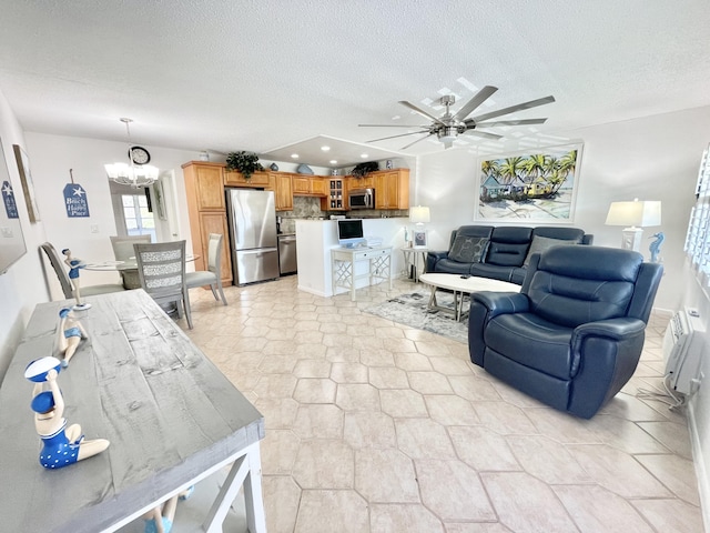 living room featuring ceiling fan with notable chandelier, a textured ceiling, and light tile floors