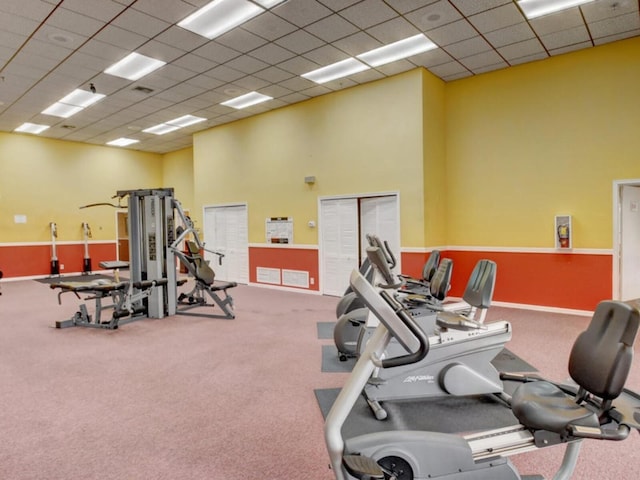 gym with a drop ceiling and carpet flooring