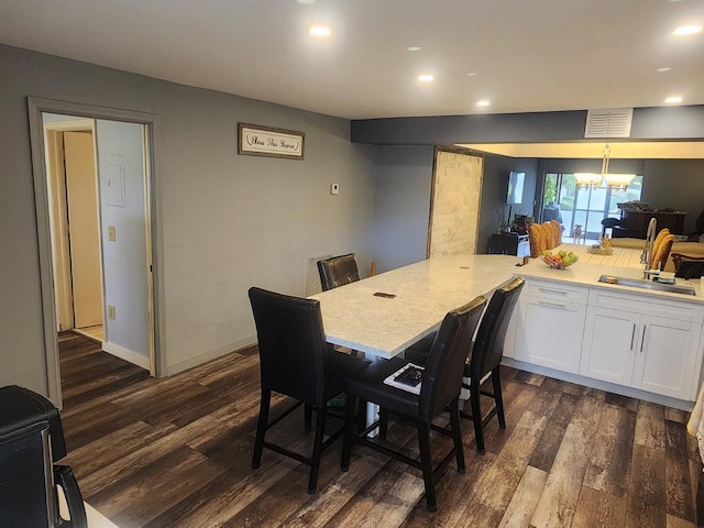 dining space featuring dark hardwood / wood-style floors, sink, and a notable chandelier