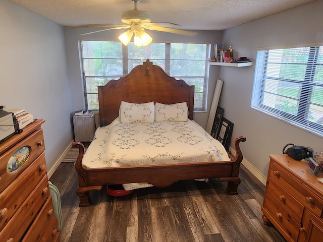 bedroom with a textured ceiling, ceiling fan, radiator, and dark wood-type flooring