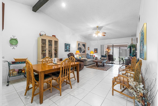 dining area featuring ceiling fan, a textured ceiling, light tile patterned floors, and vaulted ceiling with beams