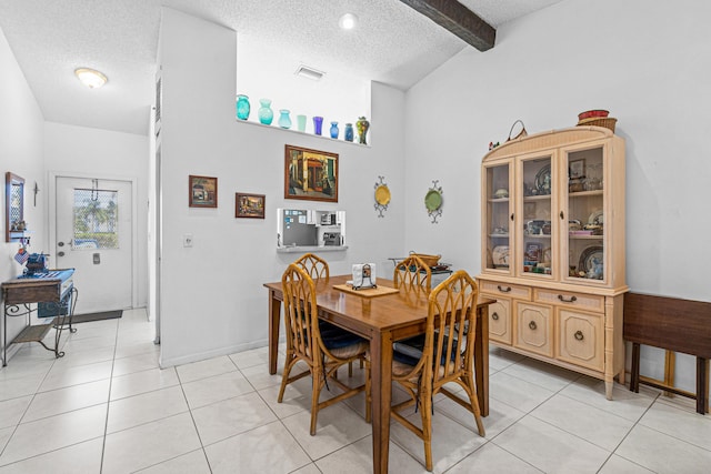 tiled dining space with a textured ceiling and lofted ceiling with beams