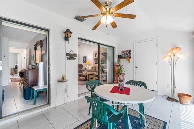 dining area with ceiling fan, light tile patterned floors, and lofted ceiling