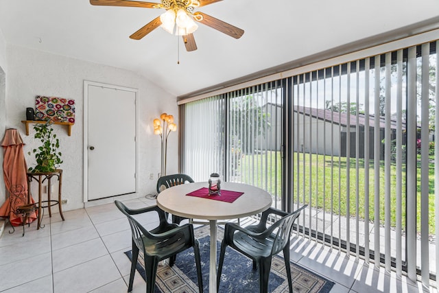 tiled dining space with ceiling fan and vaulted ceiling