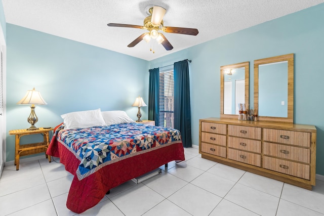 tiled bedroom with ceiling fan and a textured ceiling