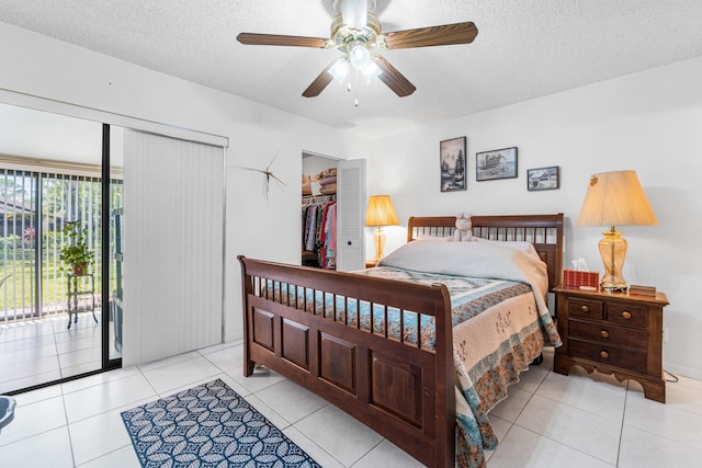 tiled bedroom with a textured ceiling, ceiling fan, a closet, and access to outside