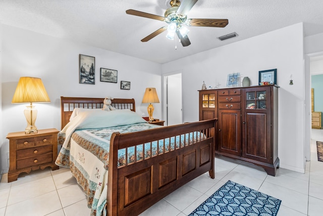 tiled bedroom with a textured ceiling and ceiling fan