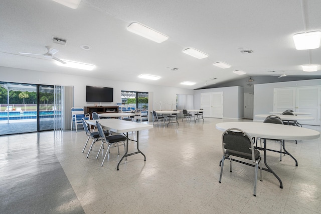 dining room featuring ceiling fan, a textured ceiling, and lofted ceiling