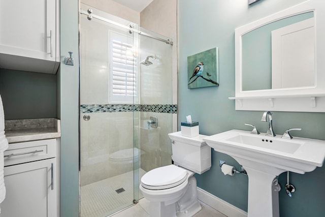 bathroom with a shower with door, toilet, and tile flooring