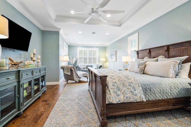 bedroom featuring crown molding, dark wood-type flooring, ceiling fan, and a raised ceiling