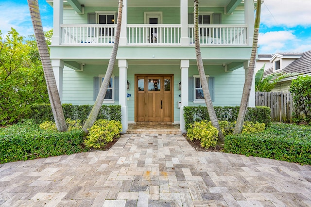 doorway to property featuring a balcony and a porch