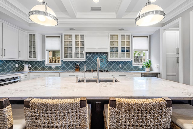 kitchen featuring hanging light fixtures, an island with sink, and a breakfast bar