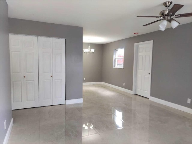 unfurnished bedroom with ceiling fan with notable chandelier, a closet, and light tile flooring