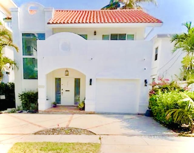 mediterranean / spanish-style house with a garage