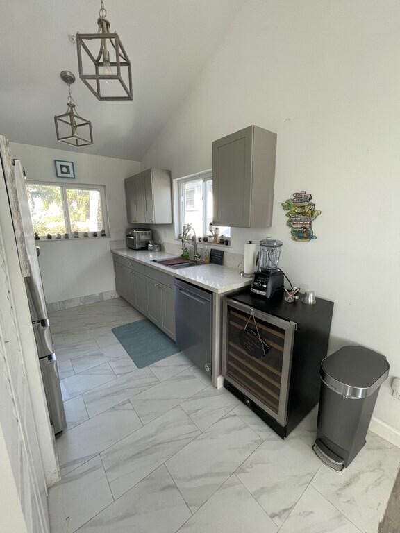 kitchen with gray cabinets, sink, stainless steel dishwasher, and light tile patterned floors