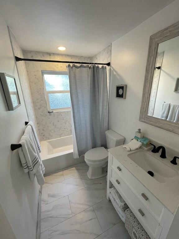 full bathroom featuring vanity, tile patterned flooring, toilet, and shower / tub combo with curtain