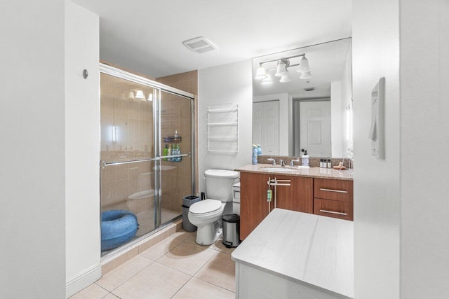 bathroom with vanity, tile patterned flooring, toilet, and walk in shower