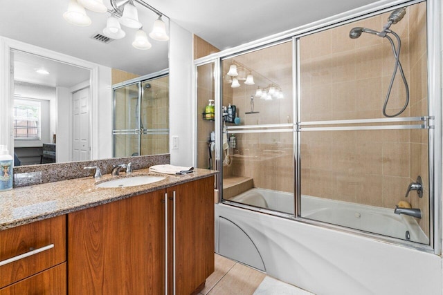 bathroom with tile patterned floors, vanity, and shower / bath combination with glass door