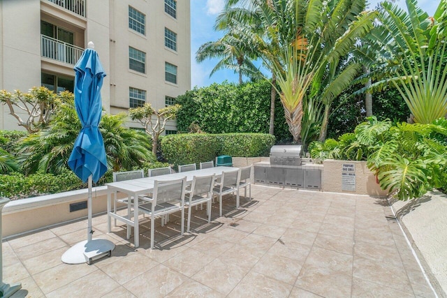 view of patio with an outdoor kitchen and a grill