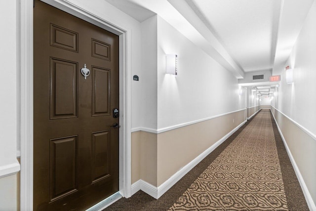 corridor featuring dark colored carpet