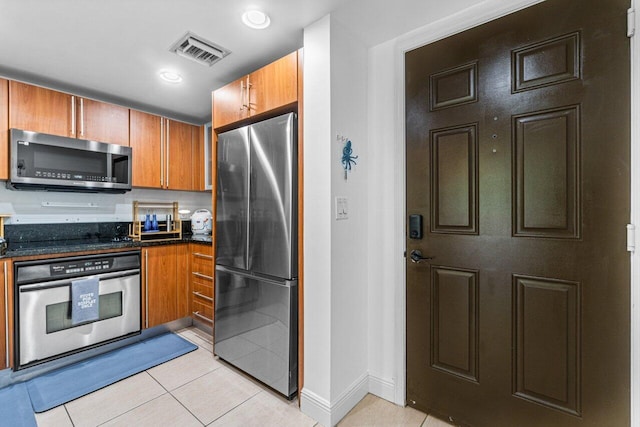 kitchen featuring stainless steel appliances and light tile patterned floors