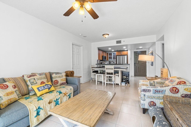 tiled living room with ceiling fan and a textured ceiling