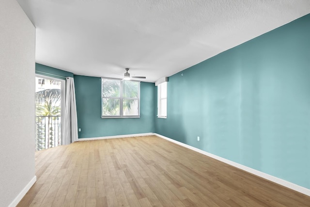 empty room featuring ceiling fan, wood finished floors, and baseboards