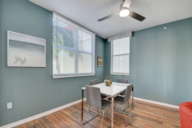 dining area featuring wood finished floors, ceiling fan, and baseboards
