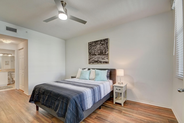 bedroom featuring connected bathroom, ceiling fan, visible vents, light wood-style flooring, and baseboards