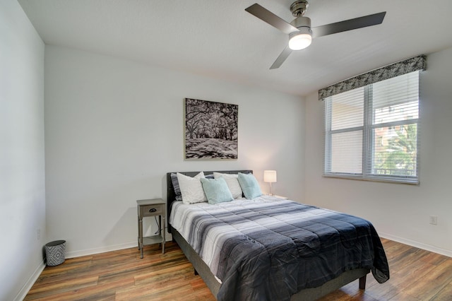 bedroom with wood finished floors, ceiling fan, and baseboards