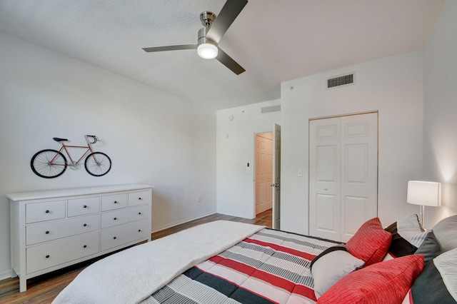 bedroom with a closet, ceiling fan, and dark hardwood / wood-style flooring