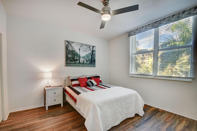 bedroom with a ceiling fan, wood finished floors, and baseboards
