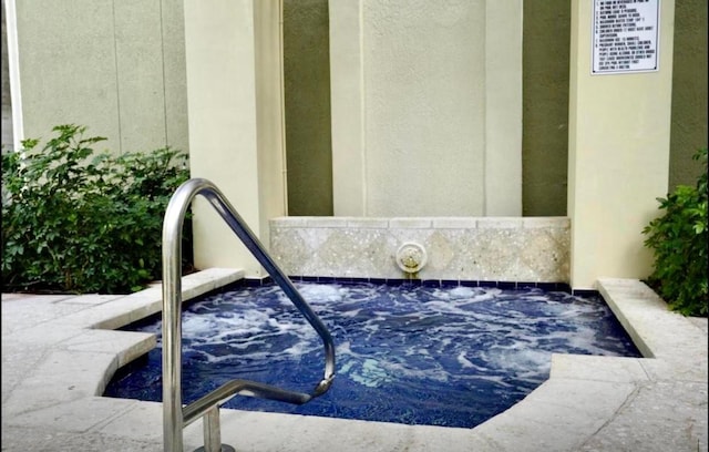 exterior space with stucco siding and a hot tub