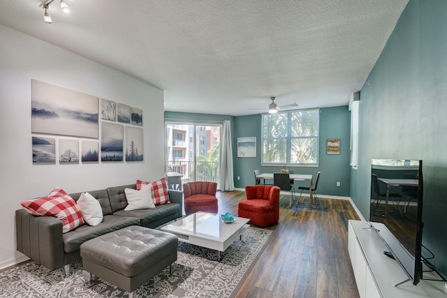 living room with ceiling fan, hardwood / wood-style flooring, and a textured ceiling