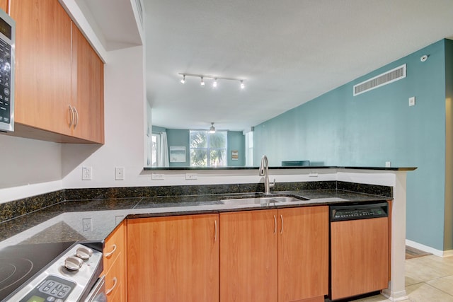 kitchen with dark stone counters, a sink, visible vents, dishwasher, and electric range