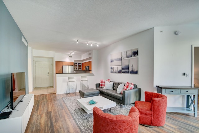 living room featuring a textured ceiling and hardwood / wood-style flooring