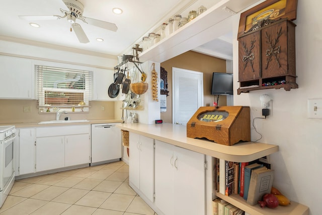 kitchen featuring white dishwasher, white cabinets, stove, and sink