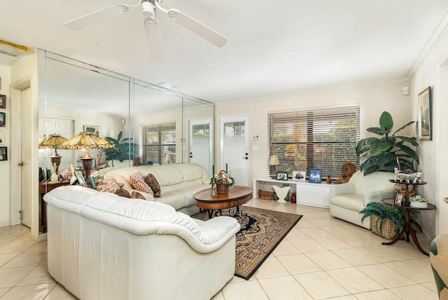 tiled living room with ceiling fan and ornamental molding