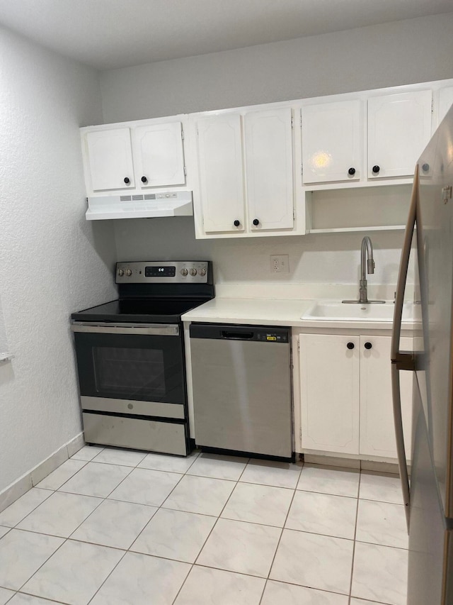 kitchen featuring appliances with stainless steel finishes, white cabinets, sink, and light tile flooring