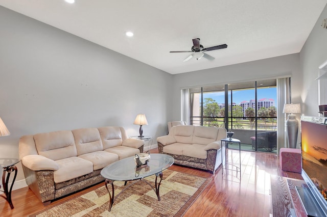 living room with light hardwood / wood-style flooring and ceiling fan