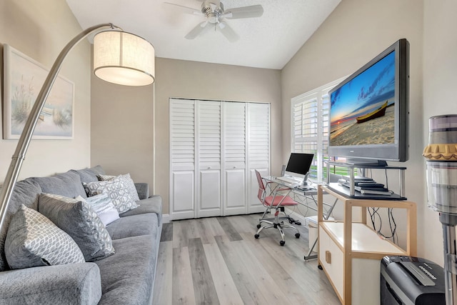 home office with light hardwood / wood-style floors, ceiling fan, and lofted ceiling