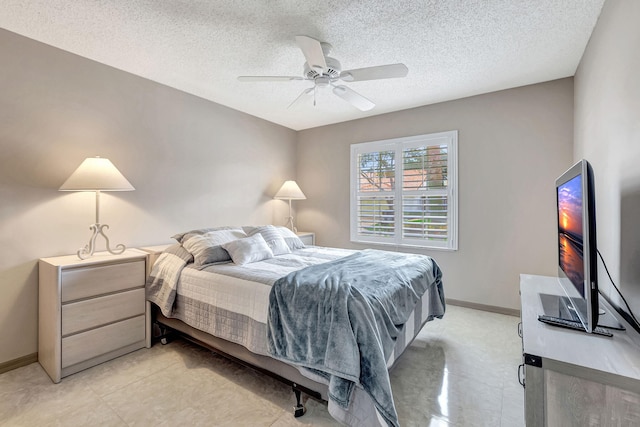 bedroom featuring ceiling fan, light tile flooring, and a textured ceiling