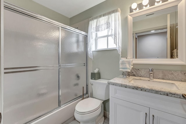 full bathroom featuring toilet, combined bath / shower with glass door, and vanity