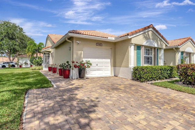 mediterranean / spanish home featuring a garage and a front yard