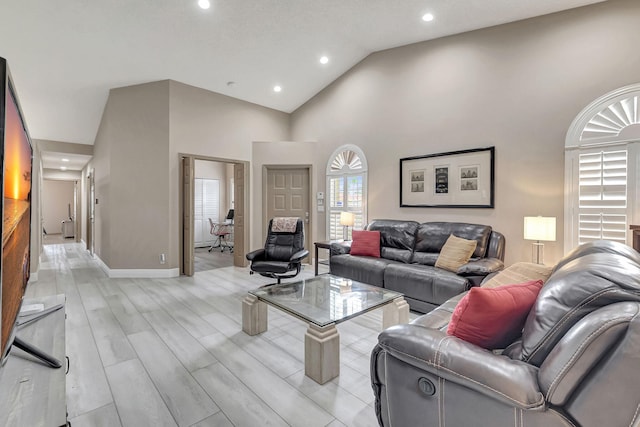 living room featuring high vaulted ceiling and light hardwood / wood-style floors