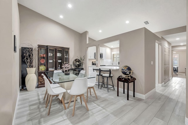 dining space with high vaulted ceiling